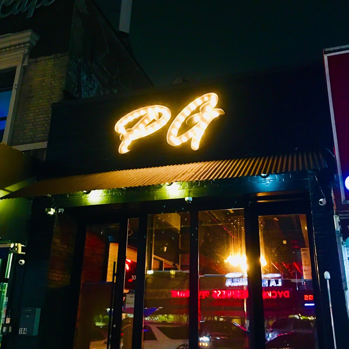 PreGame Dyckman at night — the glowing PG sign on the storefront