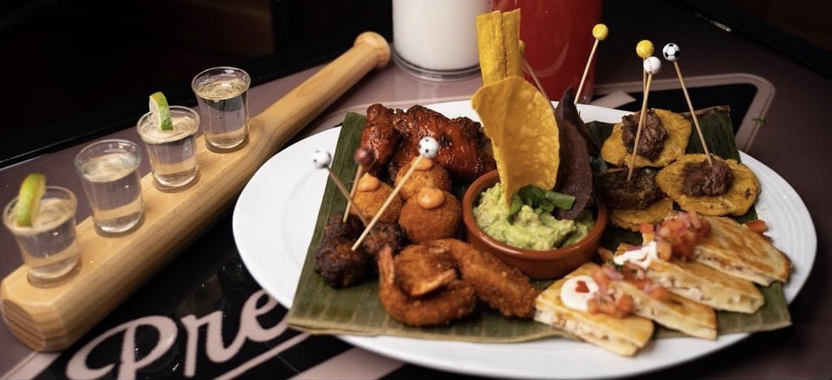 House food platter with tostones, croquettes, quesadillas, guacamole and a shot paddle at PreGame Dyckman